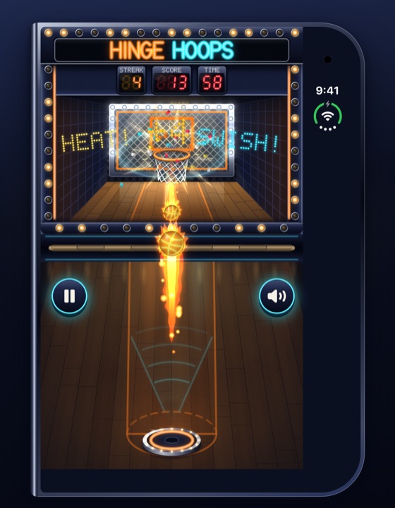 The closed phone playing on its outside screen: the cabinet above a brass rail, a ball on fire crossing the rail toward the hoop.